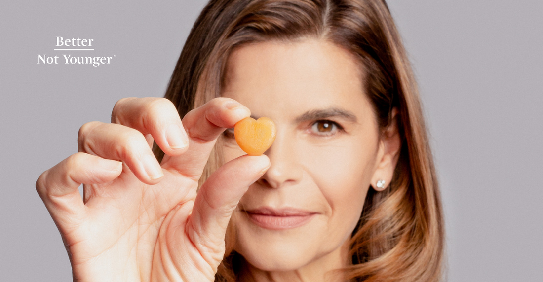 A Beautiful Mature Woman Holding A Heart Shaped Supplement Pill