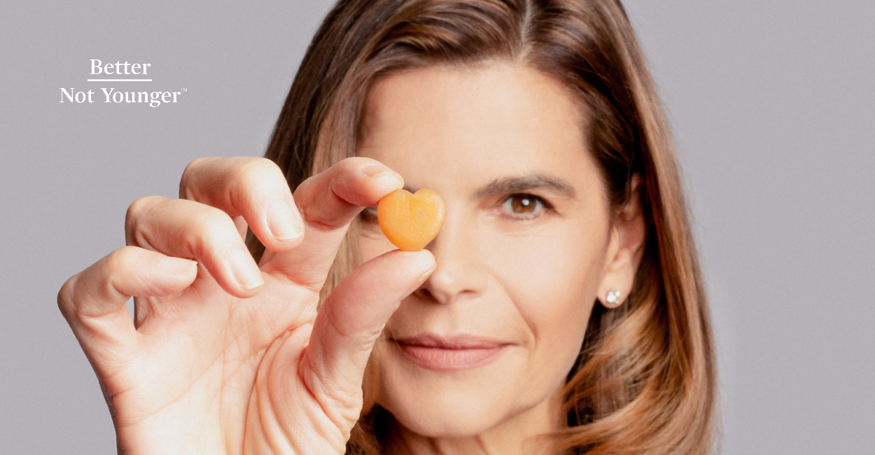 A Beautiful Mature Woman Holding A Heart Shaped Supplement Pill
