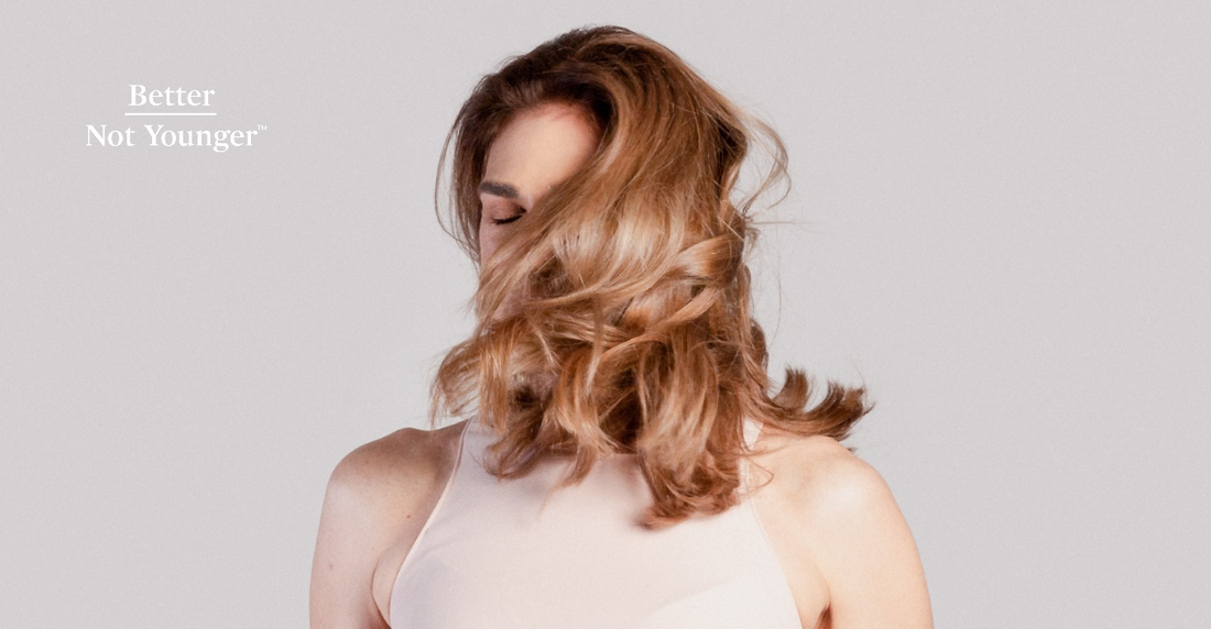 A woman with straight brown shiny hair shaking her head as a sign of joy and freedom 