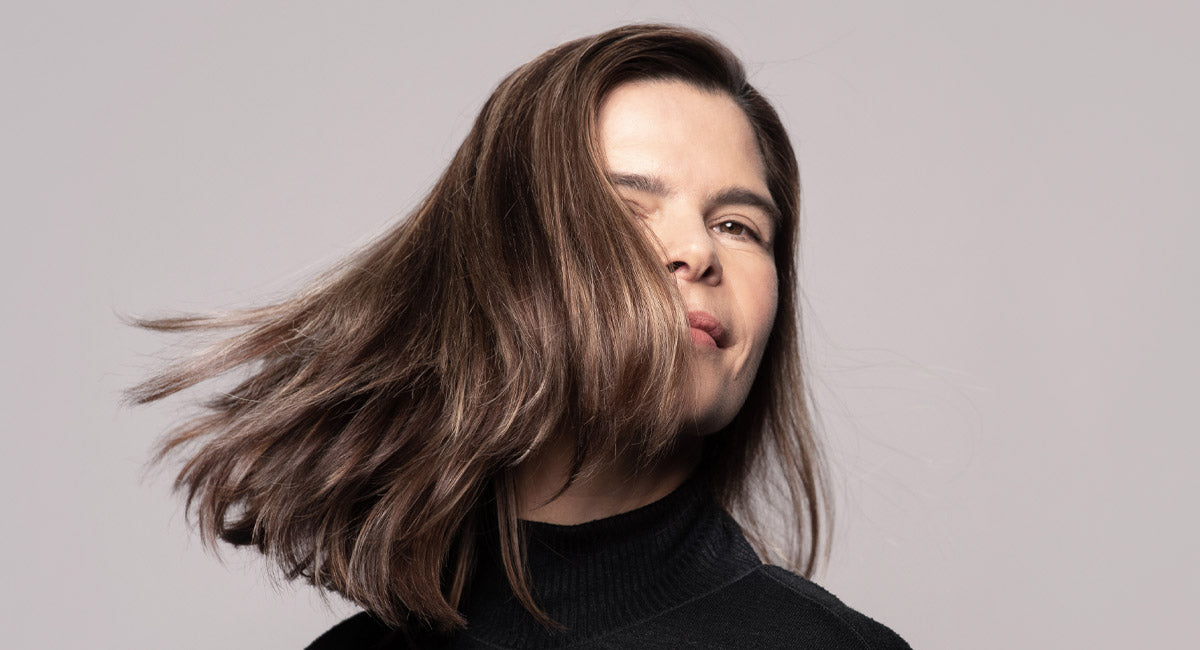 A woman over 40 is smiling and feels happy about the results of the hair mask by better not younger. 