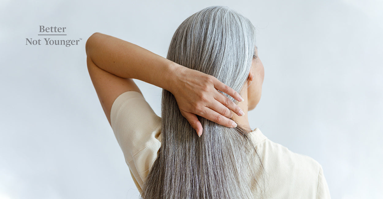 In this article about How to Increase the Anagen Phase of Hair Growth, Better Not Younger features a woman with long gray hair holding her strands