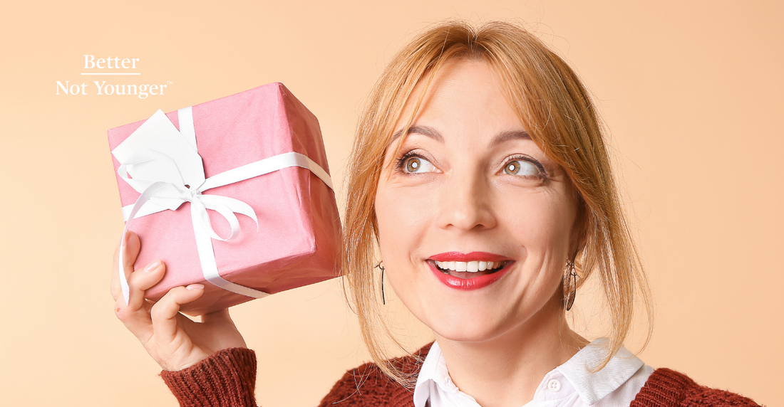 Better Not Younger features a mature woman with blonde hair trying to figure out what her gift is by getting close to the box and putting her ear near it as if she is about to shake the box. 	