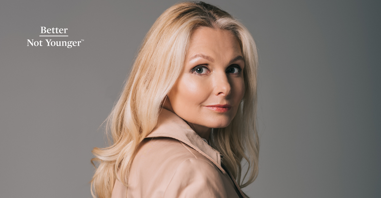 In this article How To Dye and Style Your Hair For Winter, BNY features a blonde mature woman with long hair wearing a winter coat while looking at the camera. 