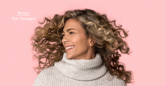 In The Cutting Edge: The Right Way to Cut Curly Hair, Better Not Younger features a mature woman with defined curly hair bouncing her strands by shaking her hair side to side while smiling.