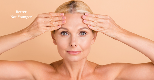 Photo of natural beauty mature lady with naked shoulders touching her forehead with perfect skin due to a perfect skin care routine during menopause