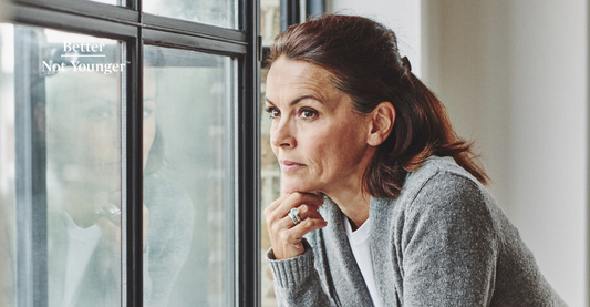 In this article about Depression, Antidepressants and Hair Loss, Better Not Younger features a mature woman with brown medium length hair looking through the window as she looks thoughtful.