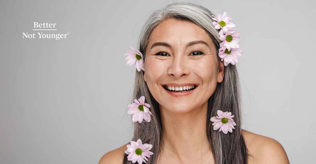 In this article "The Healthiest Diets for Your Hair", BNY features a beautiful mature asian woman with long gray hair with six natural flowers placed on both sides of her beautiful straight hair. She smiles and looks very happy.