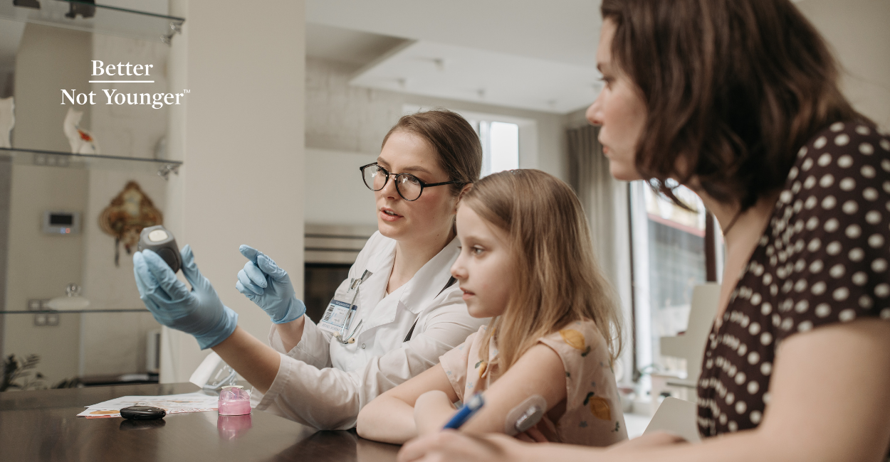 A female middle aged doctor teaching a mom and her daughter about diabetes.
