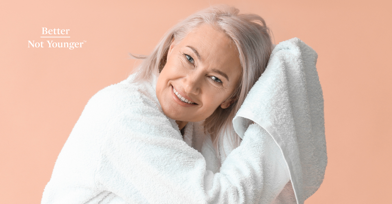 In "Why Going to Bed with Wet Hair Is a Bad Idea", BNY features a mature woman with medium gray hair drying her hair with a white towel while she smiles.